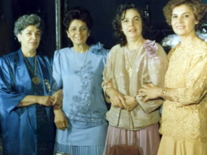 Helena Corpa Fernandes Guerreiro aparece ao lado de suas três irmãs—Anna, Tereza e Cândida—em um retrato que captura a proximidade e o carinho que as uniam. As quatro filhas de Antonio Corpa e Cândida Corpa posam juntas, refletindo os laços familiares fortes que caracterizaram a família numerosa de Caconde-SP e o legado de empenho e honestidade transmitido pelos pais.